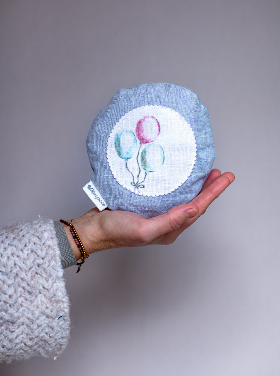 Rundes Dinkelkissen aus Leinen Farbe Hellblau mit Luftballons auf weißem Patch.
