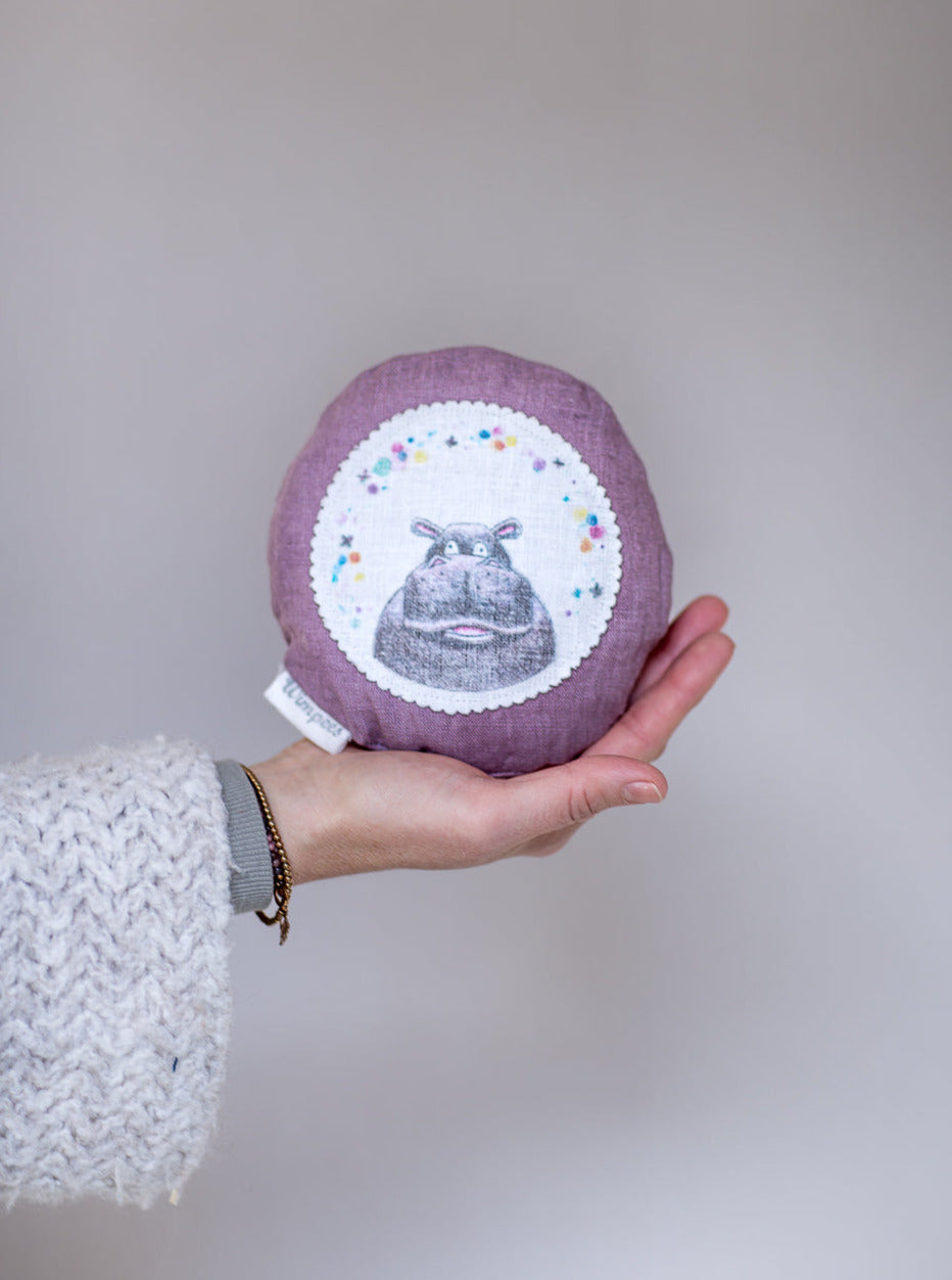 Rundes Dinkelkissen aus Leinen Farbe Lavendel mit Nilpferd auf weißem Patch.
