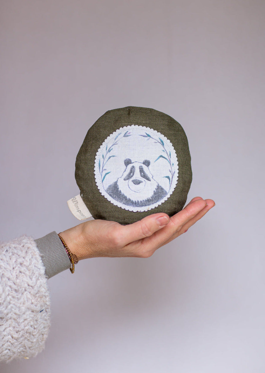 Rundes Dinkelkissen aus Leinen Farbe Dunkelgrün mit Panda auf weißem Patch.