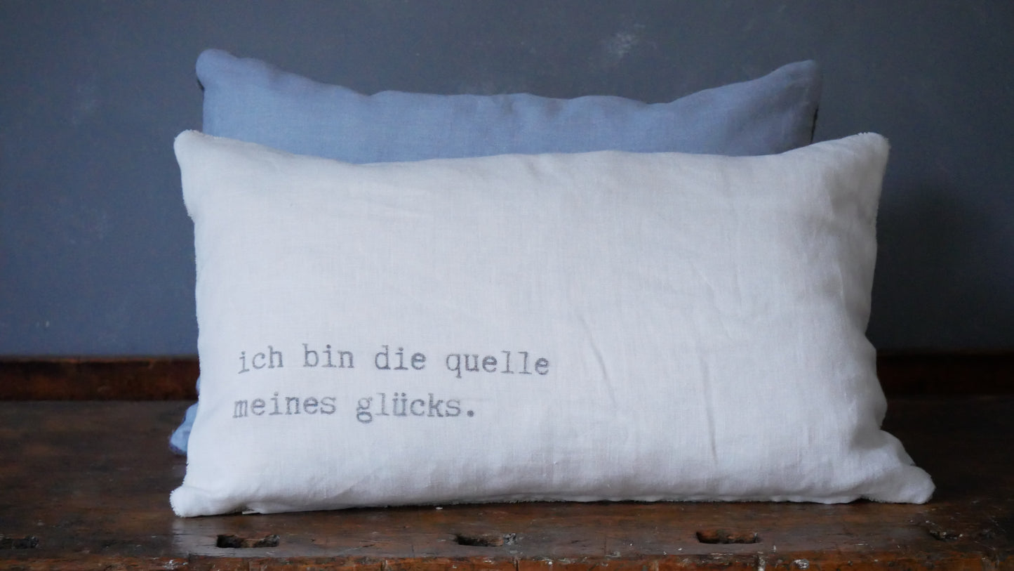 Wisses Leinenkissen mit Aufdruck "ich bin die quelle meines glücks."