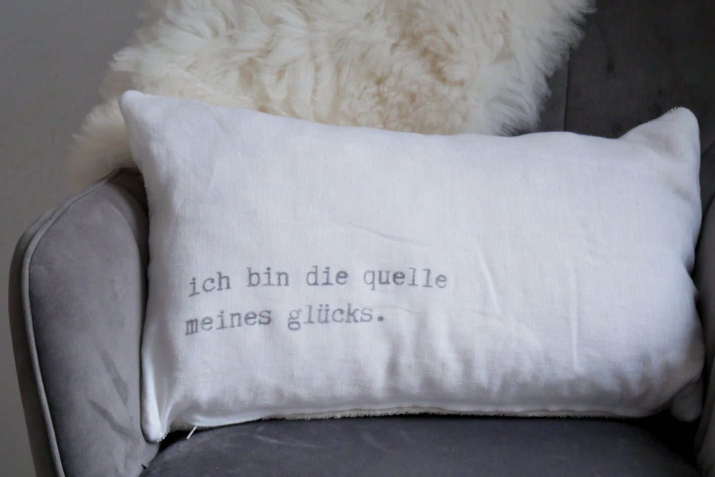 Weißes Leinenkissen mit Aufdruck "ich bin die quelle meines glücks."