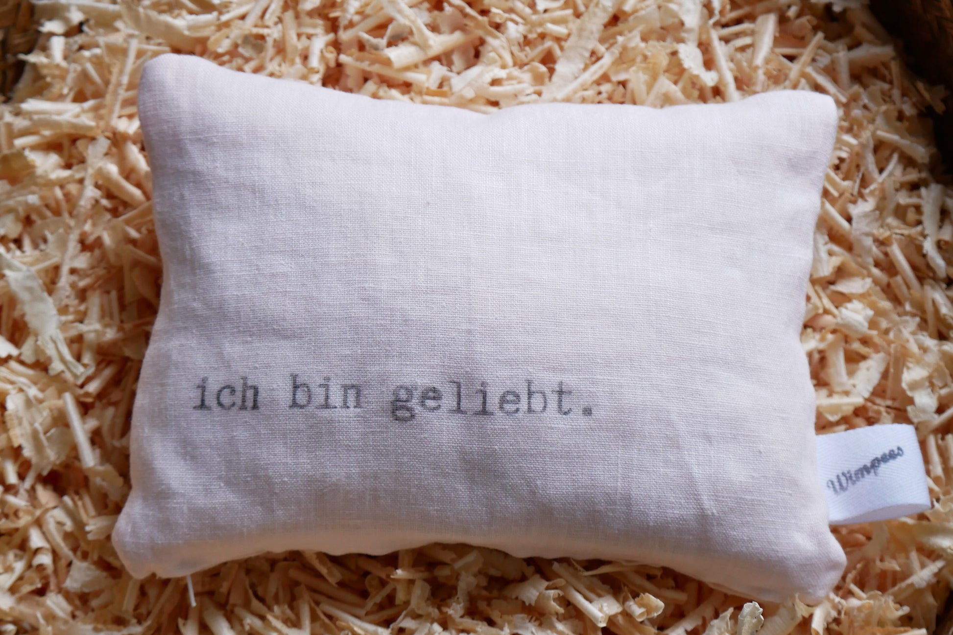 Zartrosa Leinenkissen mit Aufdruck "ich bin geliebt."